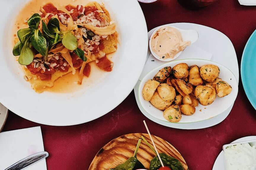 A colorful spread of gourmet dishes on a classy dinner table setting.